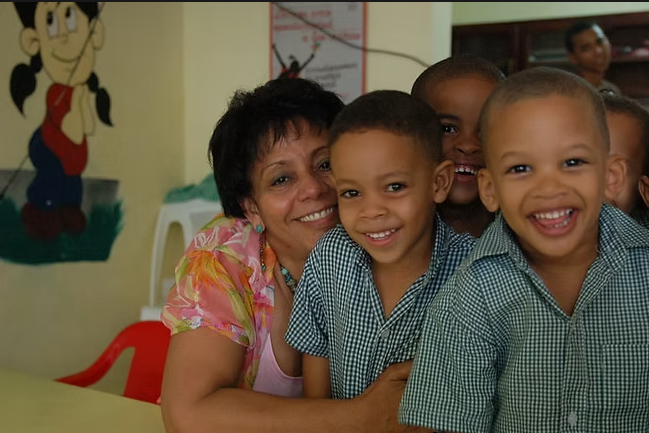 Tamarah Santana junto a niños en una estancia infantil